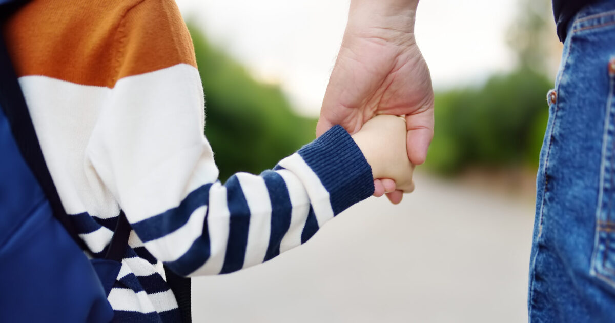 Un enfant donne la main à son papa