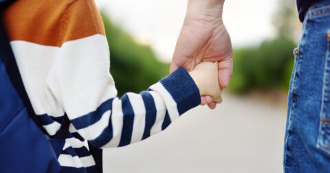 Un enfant donne la main à son papa