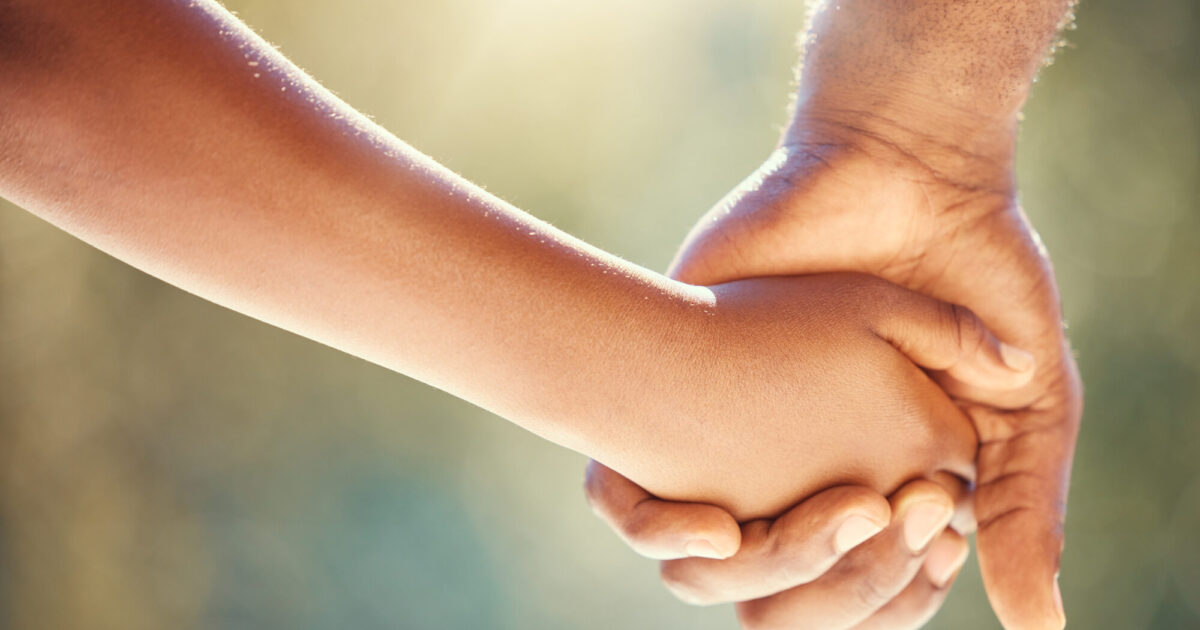 Un enfant donne la main à son papa