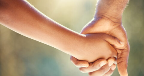 Un enfant donne la main à son papa