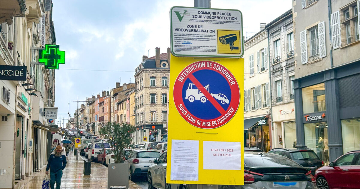 Photo de la rue Nationale, illustrant les panneaux de signalisation avec l'arrêté municipal : Interdiction de stationner sous peine de mise en fourrière le 28 septembre 2025 de 5h à 23h.