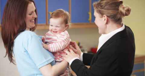 Une mère de famille montre son bébé à une assistante maternelle